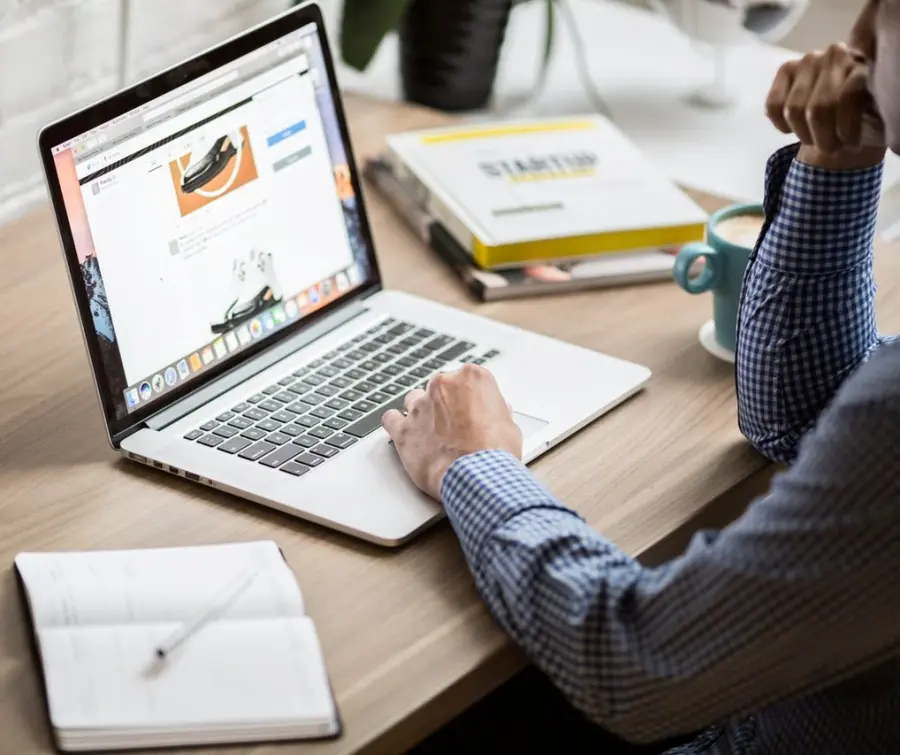 Persona al lavoro su un portatile con un sito web aperto